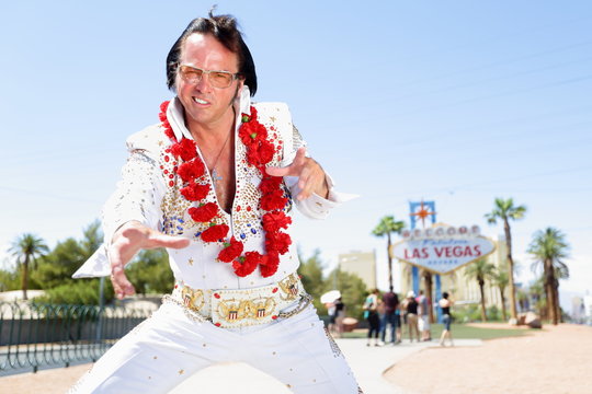 Elvis impersonator dancing by Las Vegas sign