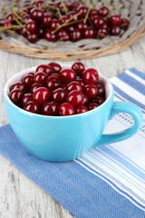 Sweet cherry in cup on table close-up