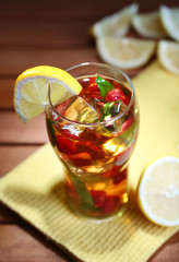 Iced tea with raspberries and mint on wooden table