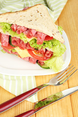 Huge sandwich on wooden table, on wooden background