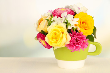Beautiful bouquet of bright flowers in color mug,