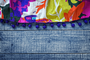 Multicolored womans skirt against blue wooden background