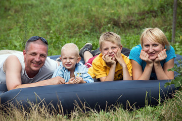 Fototapeta premium Happy mother, father and two sons in the park