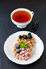 Belgian waffles with berries and a cup of tea