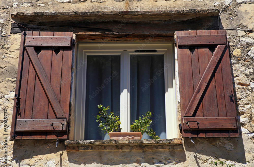 Wall mural open window with old wood shutters in stone rural house,provence