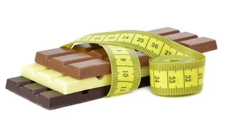 Chocolate bars with a measuring tape on white background