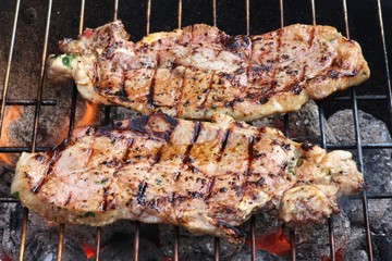 marinierte Schweinenackensteaks auf Holzkohlegrill