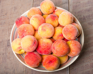 Fototapeta na wymiar Bowl of fresh yellow peaches