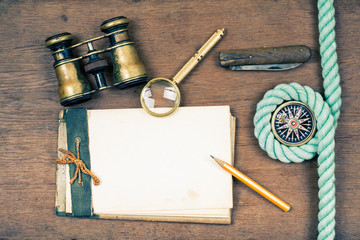 Vintage notebook, compass, binoculars, knife, pencil, magnifying