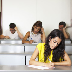 Schöne junge Studentin schreibt eine Prüfung