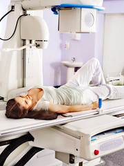 Patient  in x-ray room looking at doctor.