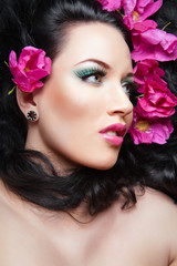 Naklejka premium beautiful brunette girl lying with pink flowers in her hair..