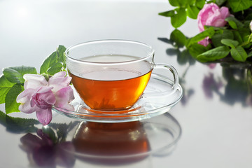 Transparent cup with green tea and fresh herbal bouquet