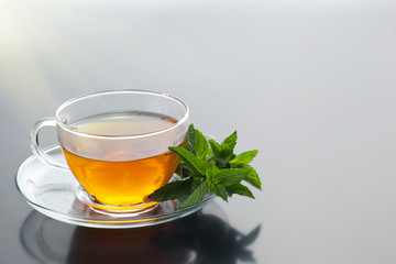 Transparent cup with green tea and fresh herbal bouquet