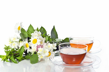 Transparent cup with green tea and fresh herbal bouquet
