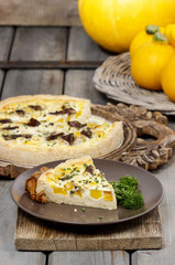 Piece of quiche lorraine on brown plate. Autumn setting