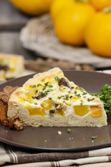 Piece of quiche lorraine on brown plate. Autumn setting