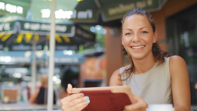 Young, attractive woman with a tablet in hand looking at camera