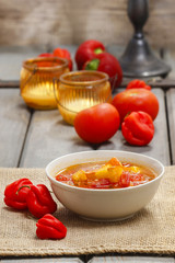 Bowl of tomato and pepper soup on wooden table. Autumn setting.