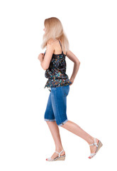 back view of running  woman. beautiful blonde girl in motion.