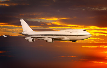 Fototapeta na wymiar samolot pasażerski w chmurach o zachodzie słońca lub świtu.
