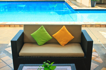 Comfortable sofa near swimming pool.