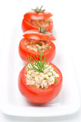 Fresh tomatoes stuffed with tuna salad, bulgur and greens