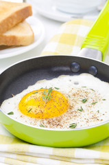 Fried eggs in a frying pan, crisp toast, coffee and orange juice