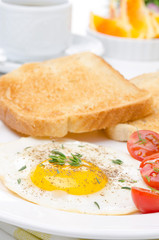 Fried eggs, fresh tomatoes and crunchy toast for breakfast