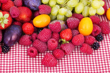 tasty summer fruits on a red tablecloth