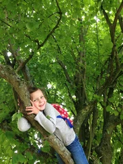 Fotobehang child in tree © Morgan