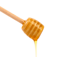 Honey dripping from a wooden dipper