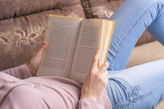 Reading a book. Cropped image of woman lying on the couch and re