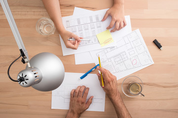 Four hands working on a desk