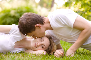 Fototapeta premium young couple lying head to head on the grass