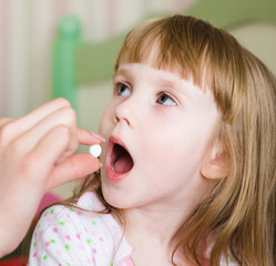 Child receiving pill - closeup