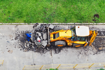 workers and tractor remove asphalt