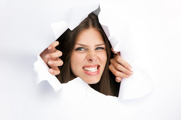 Young woman breakign through a paper sheet
