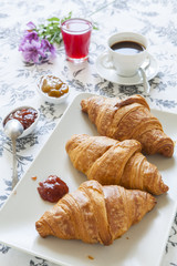 Croissants on table with jam, orange juice and coffee