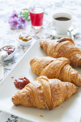 Croissants on table with jam, orange juice and coffee