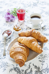Croissants on table with jam, orange juice and coffee