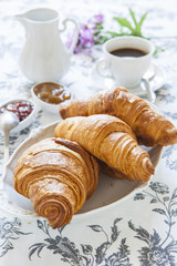 Croissants on table with jam and coffee