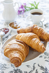 Croissants on table with jam and coffee