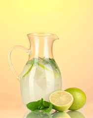 Lemonade in pitcher on yellow background