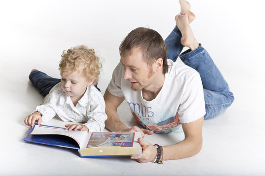 Father is reading to his son isolated on white
