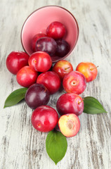 Ripe plums on wooden table close-up