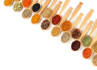 Assortment of spices in wooden spoons, isolated on white