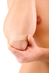Young man with adhesive bandage on hand, isolated on white