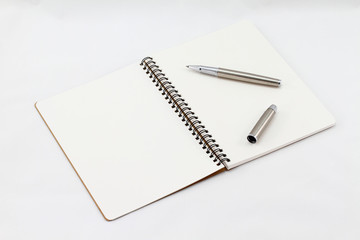 Notebook and Silver fountain pen isolated on white background