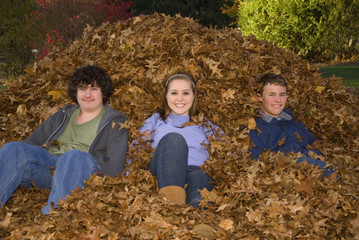Raking Leaves Three Teens Sitting in Leaf Pile